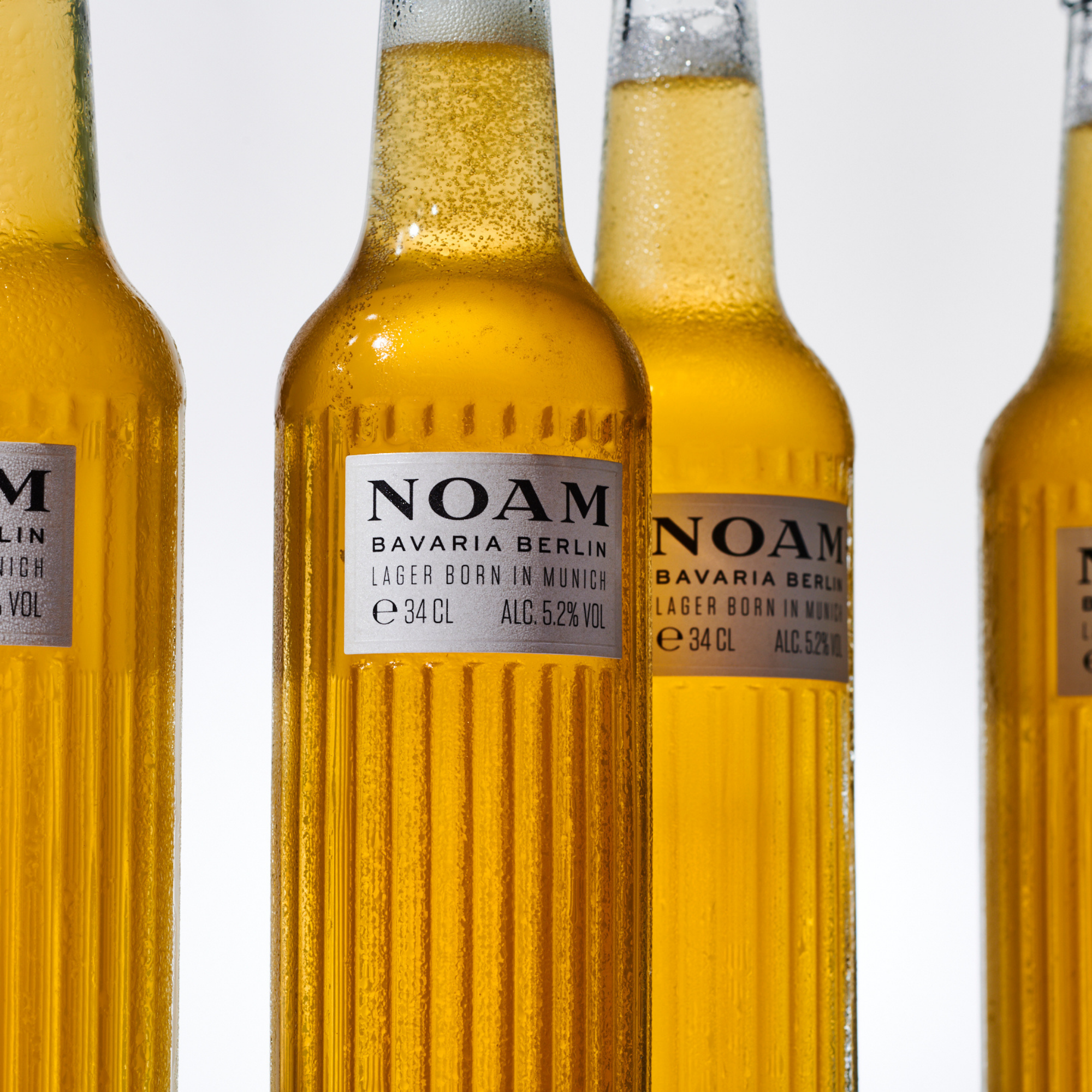 Four bottles of NOAM beer with a white background