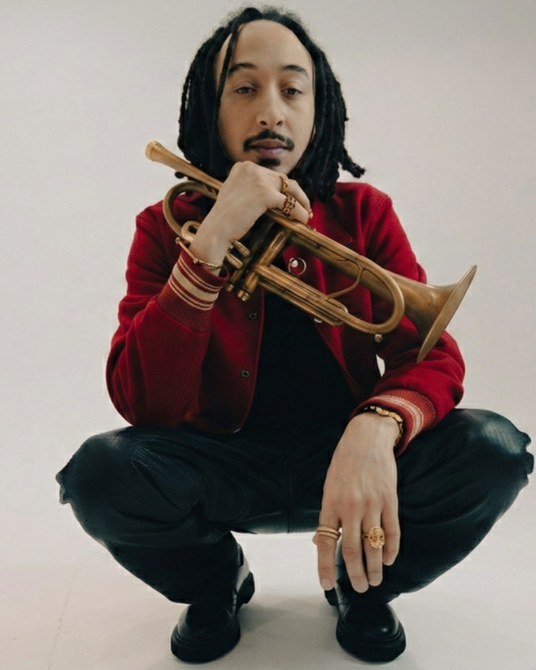 Person holding a trumpet against a plain background