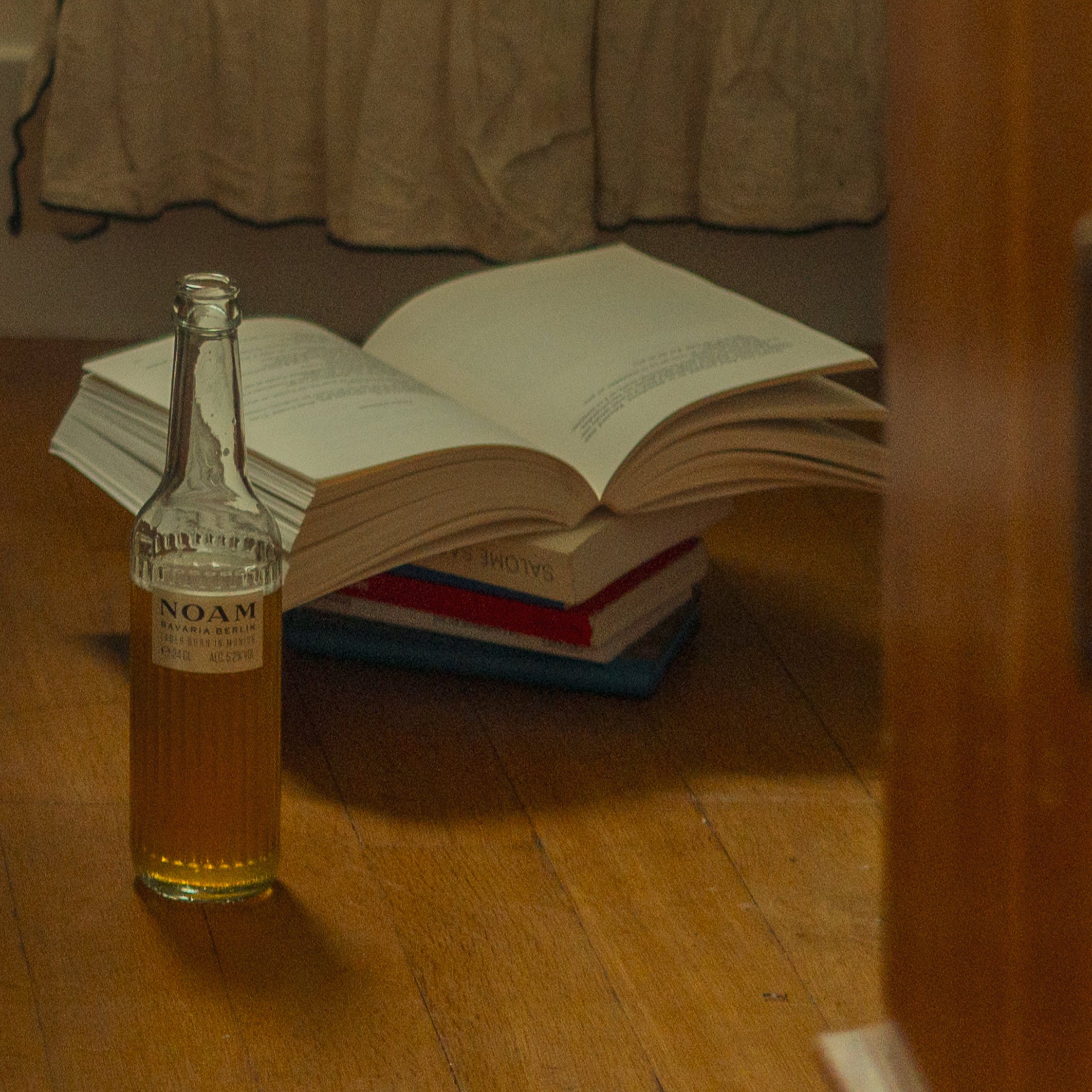 Open book with a NOAM Lager Beer, on a wooden surface.