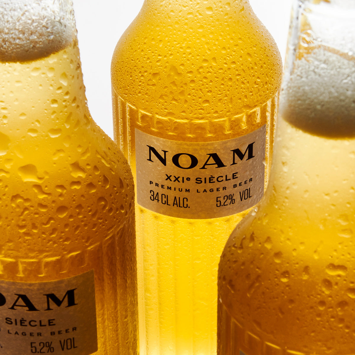 Three bottles of NOAM beer with a white background