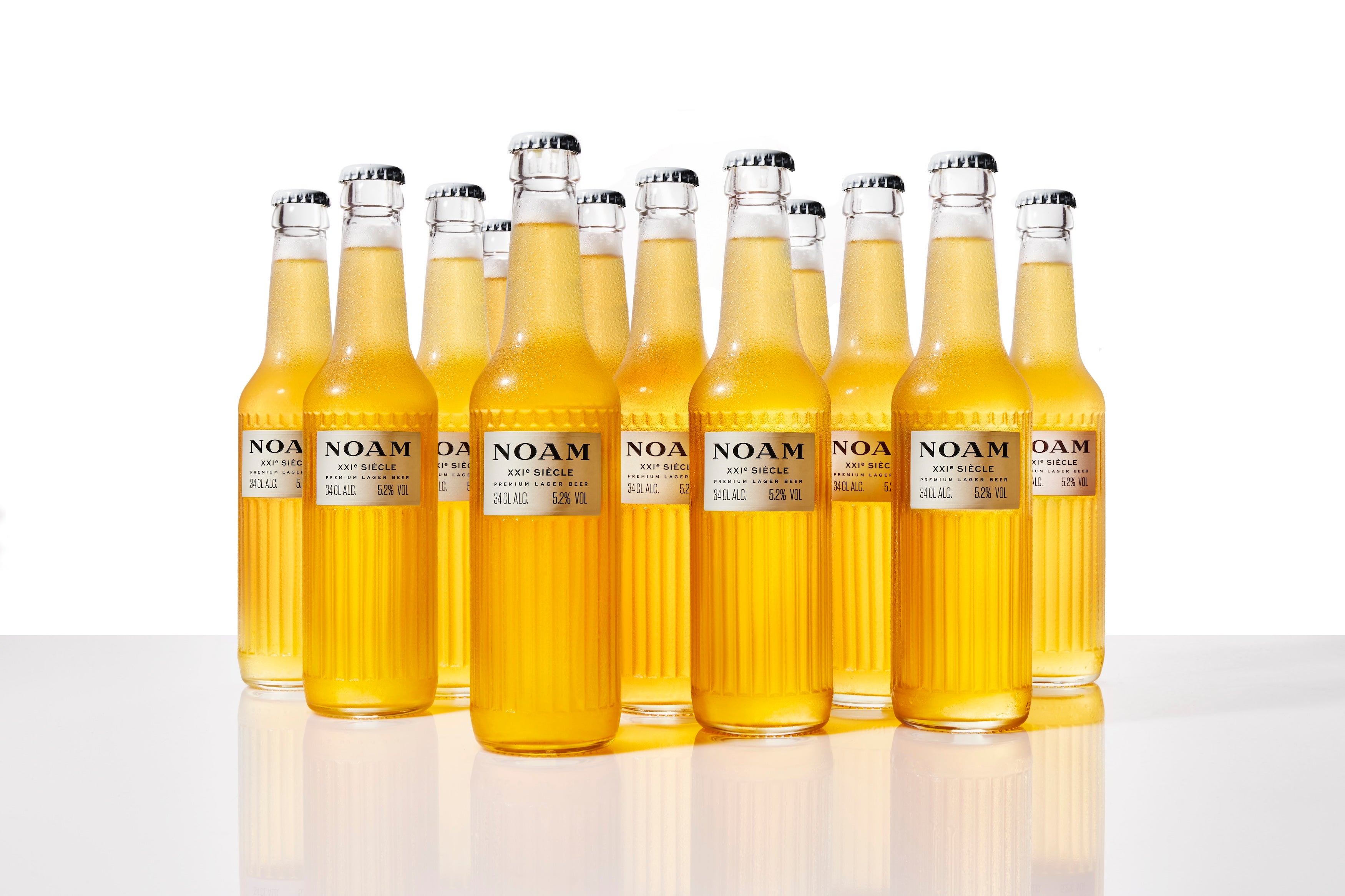 Row of NOAM bottles on a reflective surface with a white background